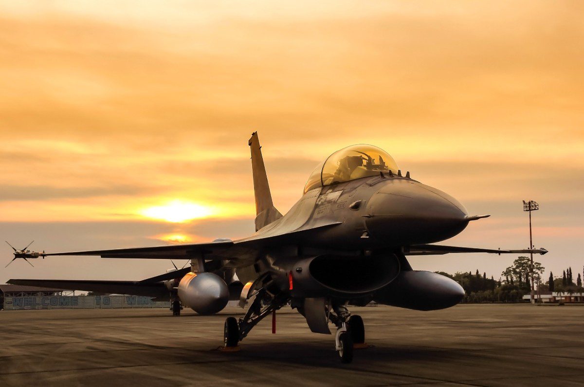f16 falcon fighter jet parked in the airforce on sunset background.